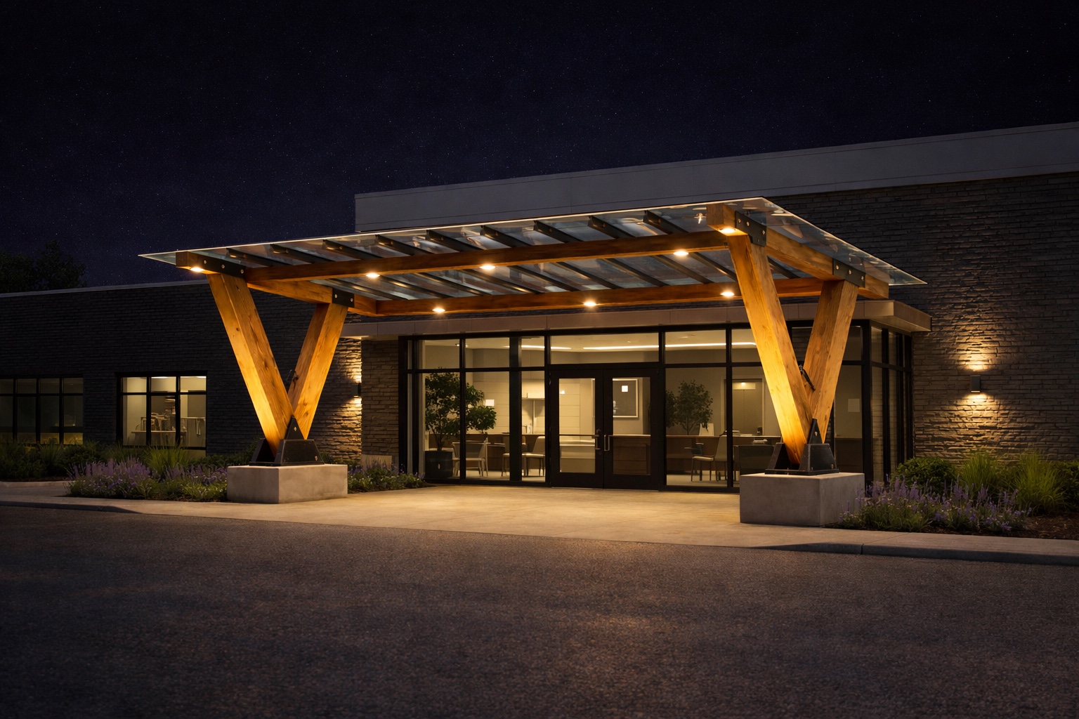 TimberShield commercial building entrance canopy at dusk with V-legs and glass roof